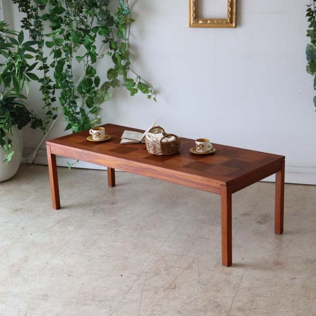 Mid-century vintage teak coffee table with rich rosewood grain, simple rectangular top, and slender straight legs,.