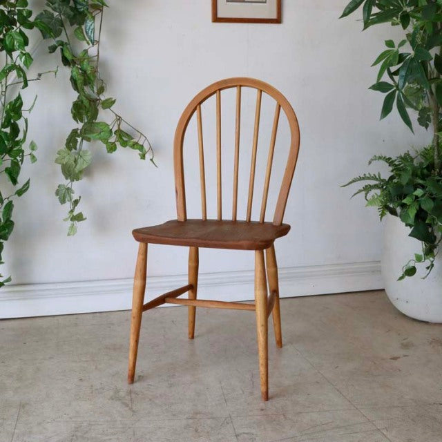 Vintage teak mid-century British Ercol hoop back dining chair with smooth wood grain and slender tapered legs.