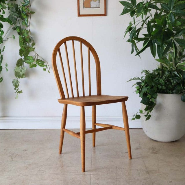 Vintage British mid-century Ercol hoop back chair in warm teak with gentle wood grain and slender tapered legs.