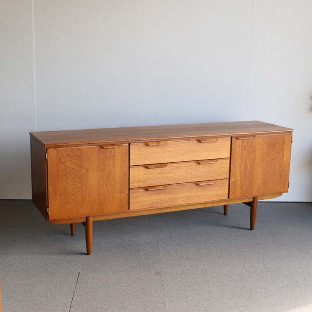Vintage mid-century Austinsuite teak sideboard with British-Danish design, smooth wood grain, tapered legs, and three.