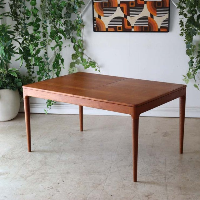 Mid-century Danish teak dining table with clean rectangular top, tapered legs, and smooth wood grain, British vintage style.