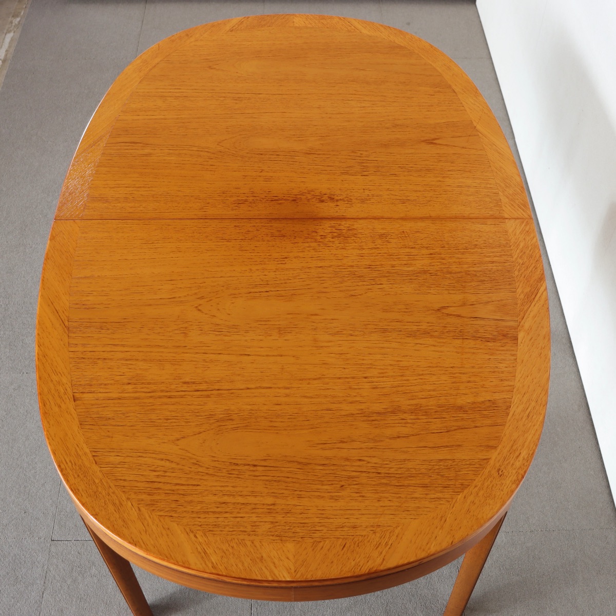 ネイサンNATHAN製オーバル型ダイニングテーブル。チーク材の豊かな木目が魅力の北欧ヴィンテージ。静かに時を重ねた深みがある。