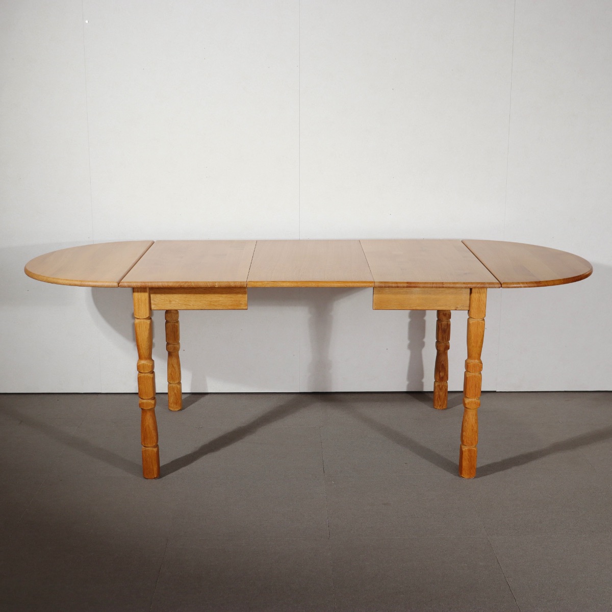 デンマーク製ダイニングテーブル。オーク材の深い色合いが印象的な北欧ヴィンテージ。控えめな品格が漂う。