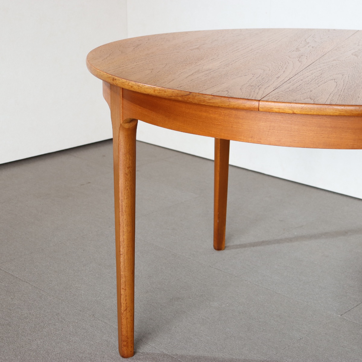 ネイサンラウンドダイニングテーブル。チーク材の豊かな色合いが魅力のヴィンテージ。高級感ある佇まい。