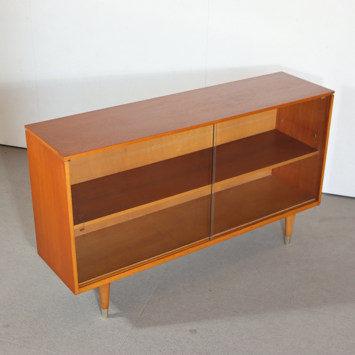 英国製ガラスブックケース。木の温もりを感じるチーク材の北欧ヴィンテージ。品のある佇まいが空間を包む。