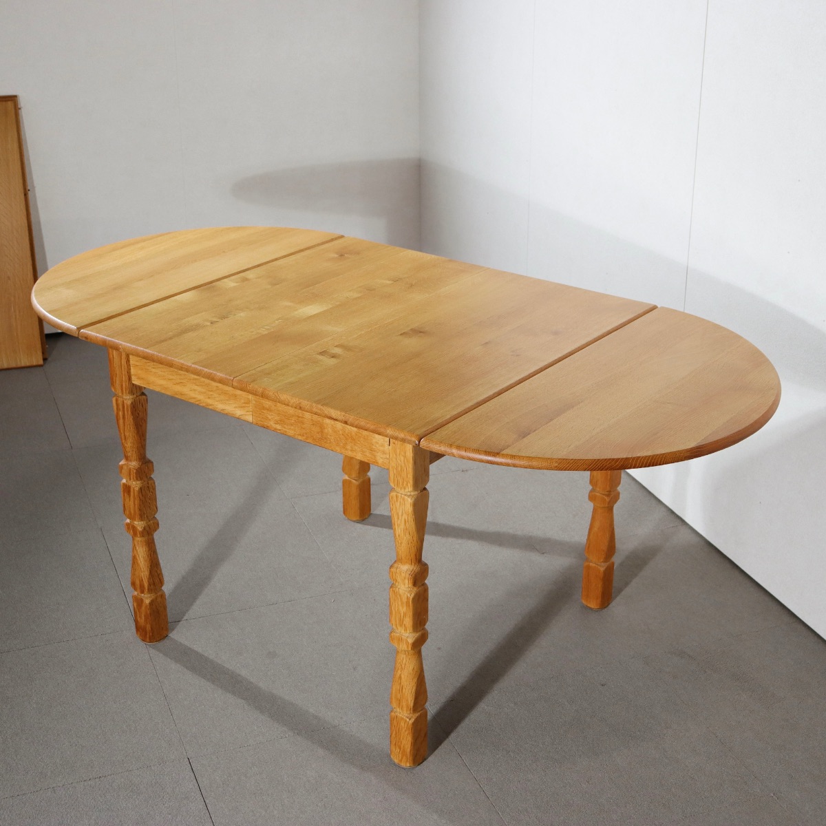 デンマーク製ダイニングテーブル。オーク材の深い色合いが印象的な北欧ヴィンテージ。控えめな品格が漂う。